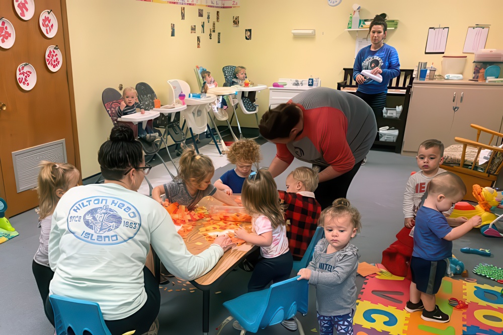 Children engaged in playful activities in a classroom, highlighting a nurturing and supportive educational atmosphere.