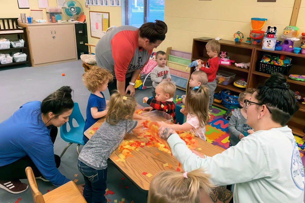 Children engaged in play with toys in a classroom setting, fostering well-rounded development through integrated curricula.