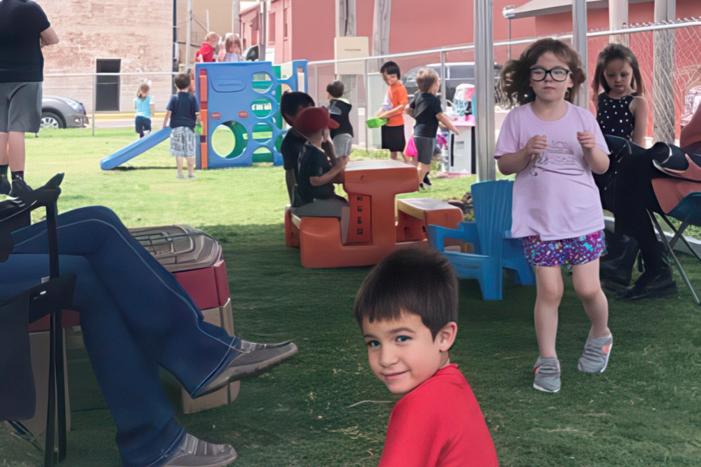 A child enjoys outdoor playtime on a playground, surrounded by peers, fostering growth and development through adventure.